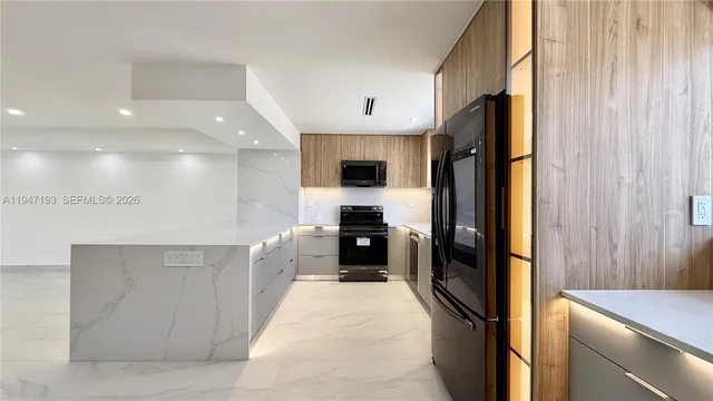 a large white kitchen with a sink and refrigerator