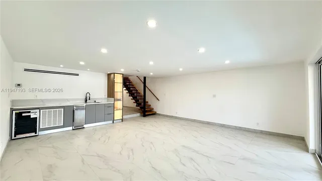 an empty room with a stove and large window