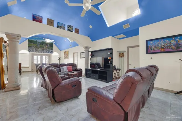 a living room with furniture a flat screen tv and kitchen view