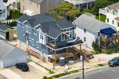 a aerial view of a house with a yard and balcony