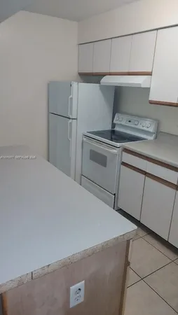 a kitchen with a refrigerator and cabinets