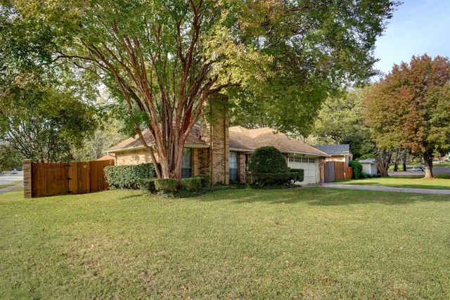 a front view of a house with a yard and trees