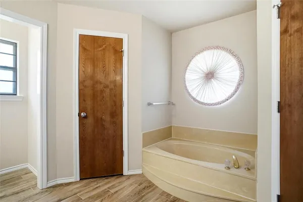 a bedroom with a bed a window and a flat screen tv