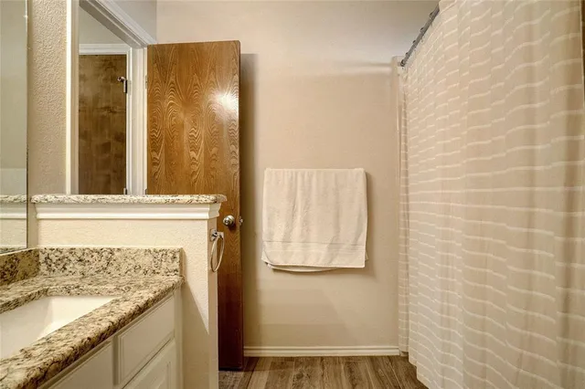 a bathroom with a granite countertop sink and a mirror