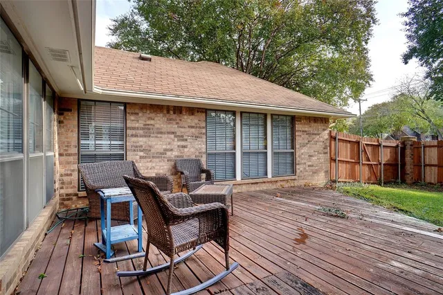 a view of a patio with table and chairs with wooden floor and fence
