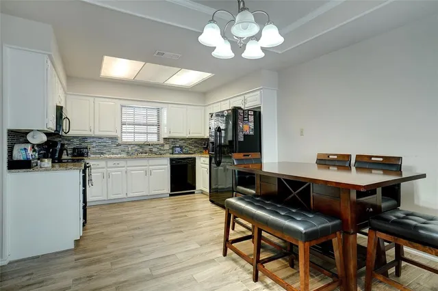 a kitchen with a center island appliances and cabinets