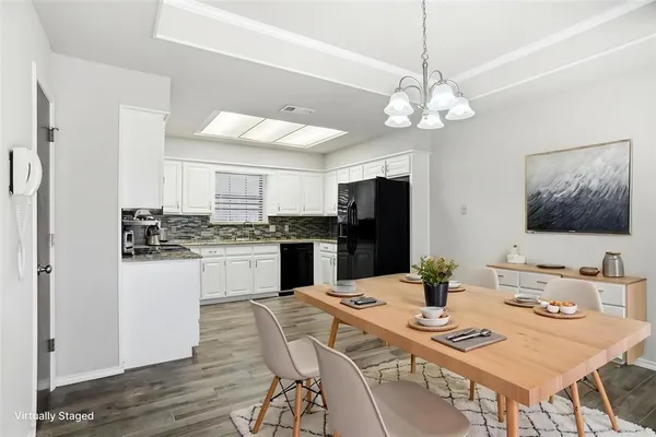 a kitchen with a refrigerator a stove dining table and chairs