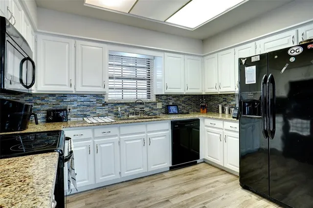 a kitchen with stainless steel appliances granite countertop a stove a sink and a microwave