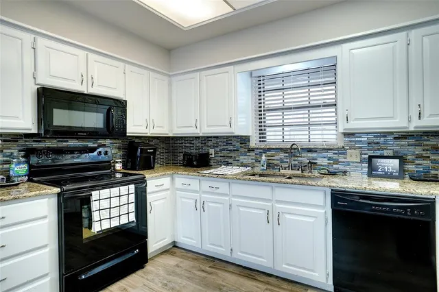 a kitchen with cabinets appliances a sink and a window