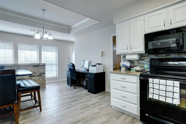a kitchen with a chandelier stainless steel appliances and dining table