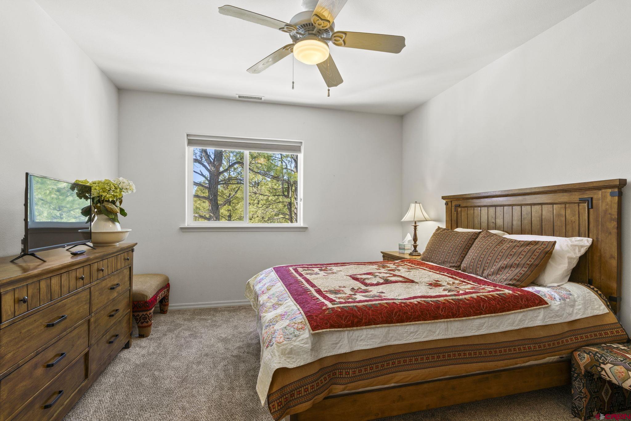 498 Woodbridge Way Durango, CO 81301 - Photo 13 of 26 a bedroom with a bed and a chandelier