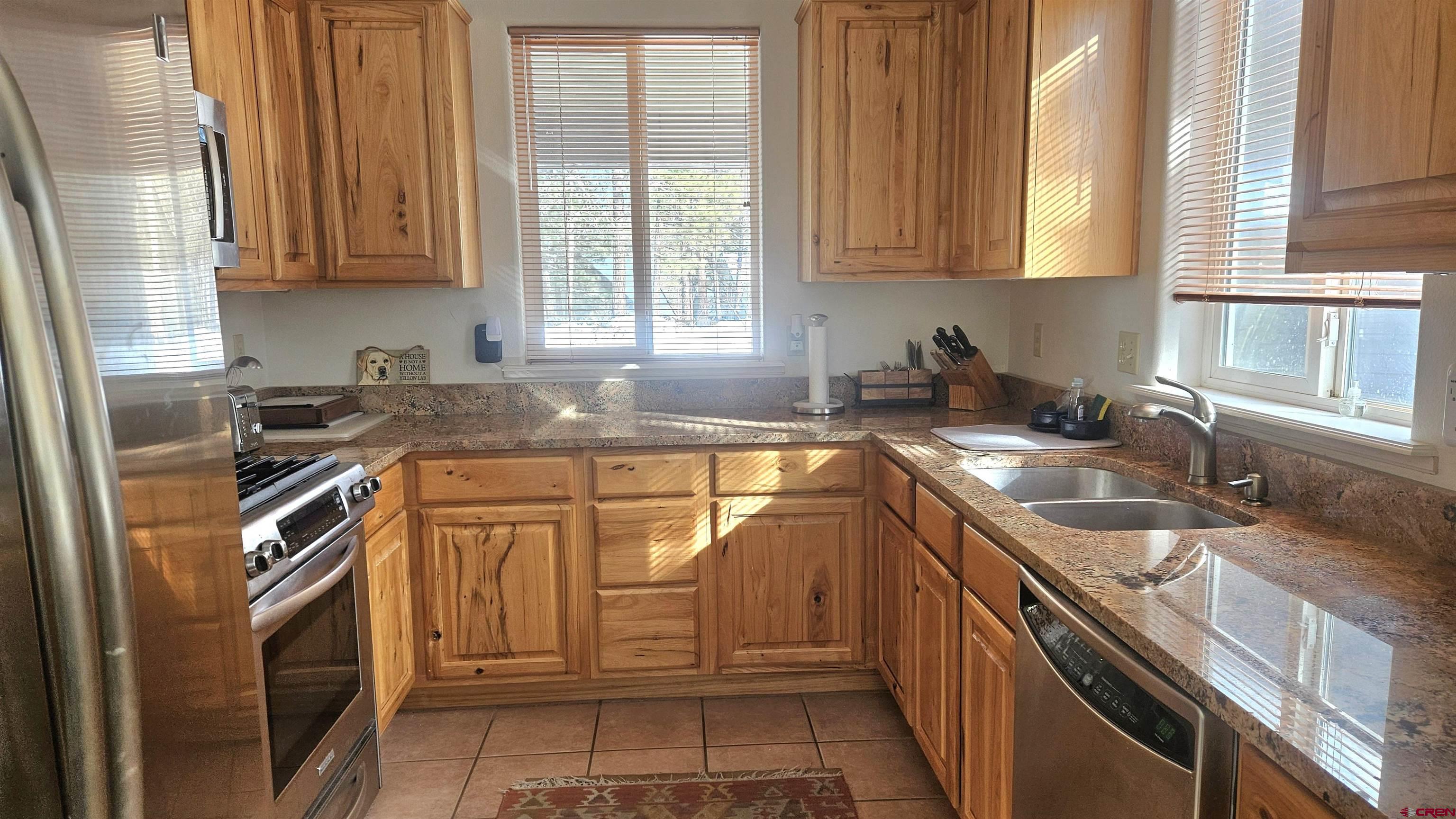 498 Woodbridge Way Durango, CO 81301 - Photo 9 of 26 a kitchen with granite countertop stainless steel appliances a sink window and cabinets