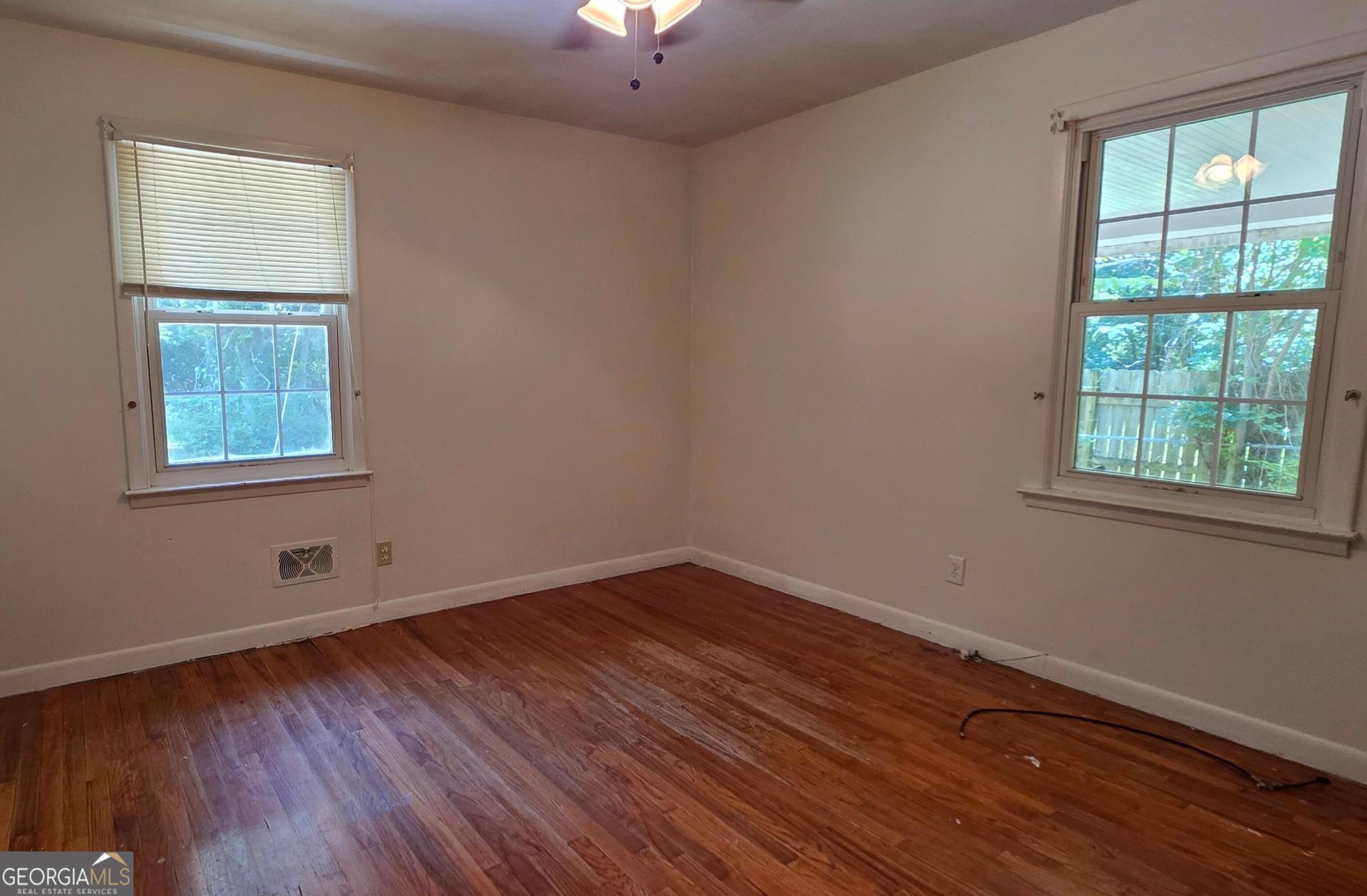 110 Lee Street Centerville, GA 31028 - Photo 8 of 16 an empty room with wooden floor and windows