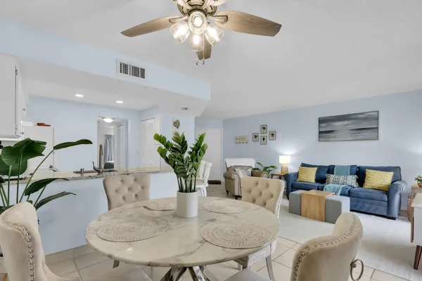 a living room with furniture chandelier and a potted plant