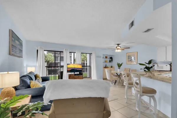 a living room with furniture and a dining table with wooden floor