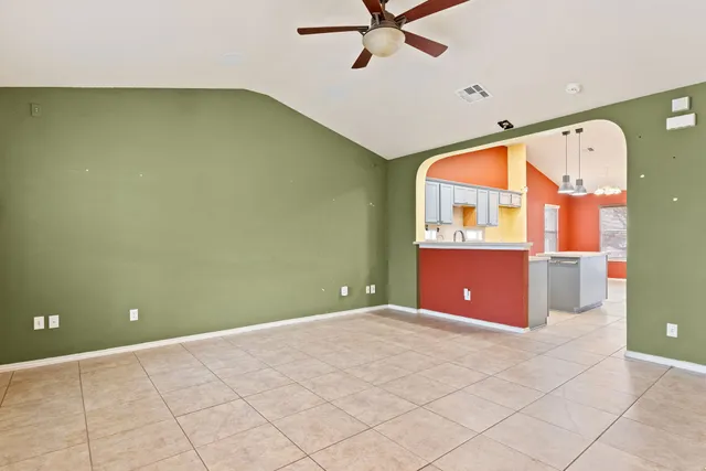 a view of a room with a ceiling fan and window