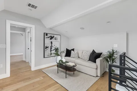 a hallway with a potted plant on a wall and a large window
