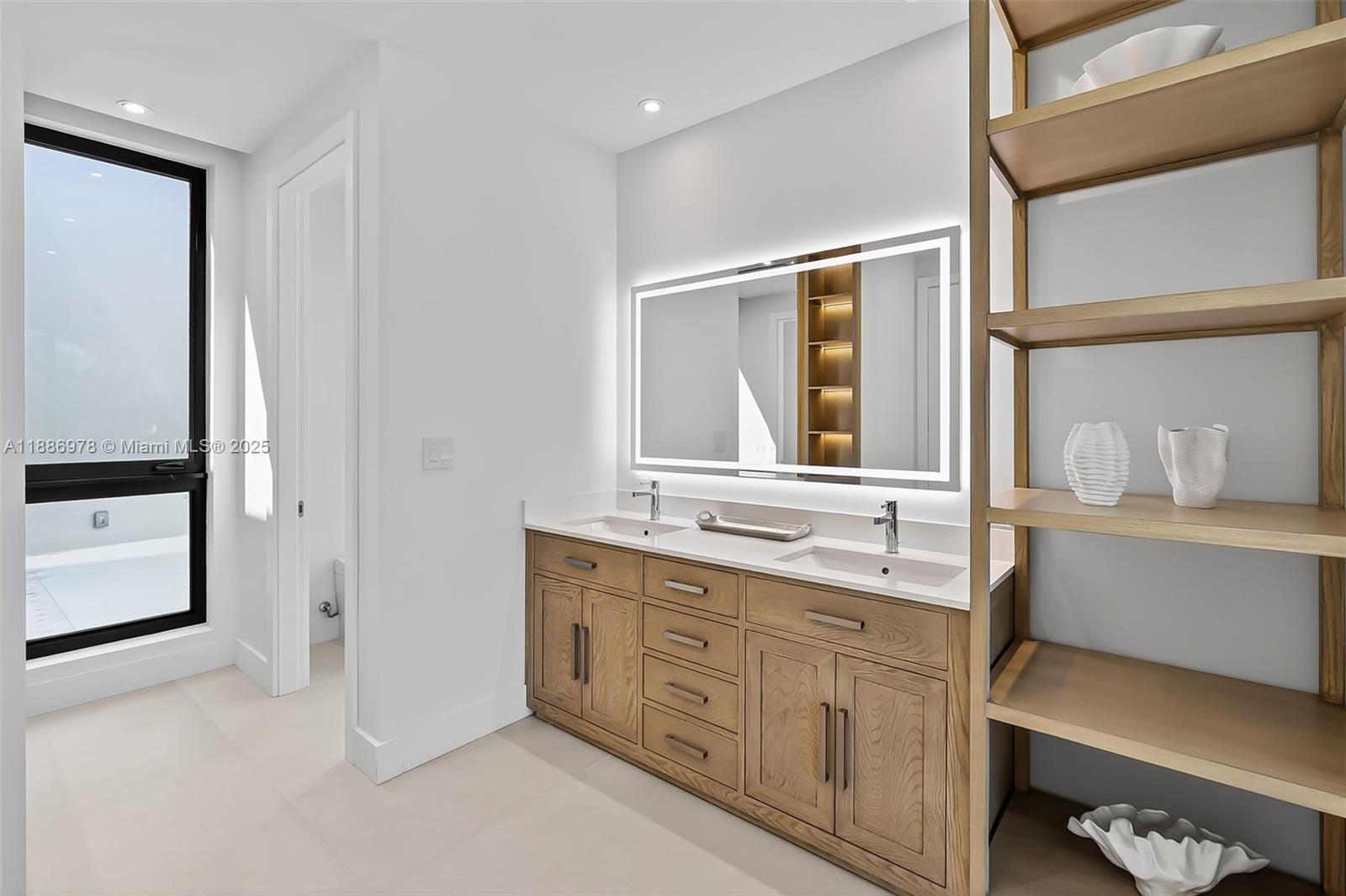 620 Solar Isle Drive Fort Lauderdale, FL 33301 - Photo 46 of 83 a bathroom with a double vanity sink a mirror and a bathtub