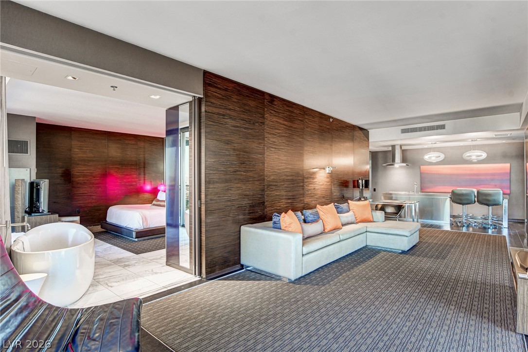 4381 West Flamingo Road, Unit 3002 Las Vegas, NV 89103 - Photo 53 of 59 Rich wood paneling and large-format tile flooring define this modern, open-concept living space.