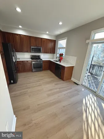 a large kitchen with stainless steel appliances wooden floors and wooden cabinets