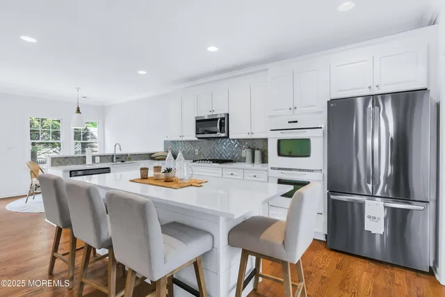 a kitchen with white cabinets and appliances