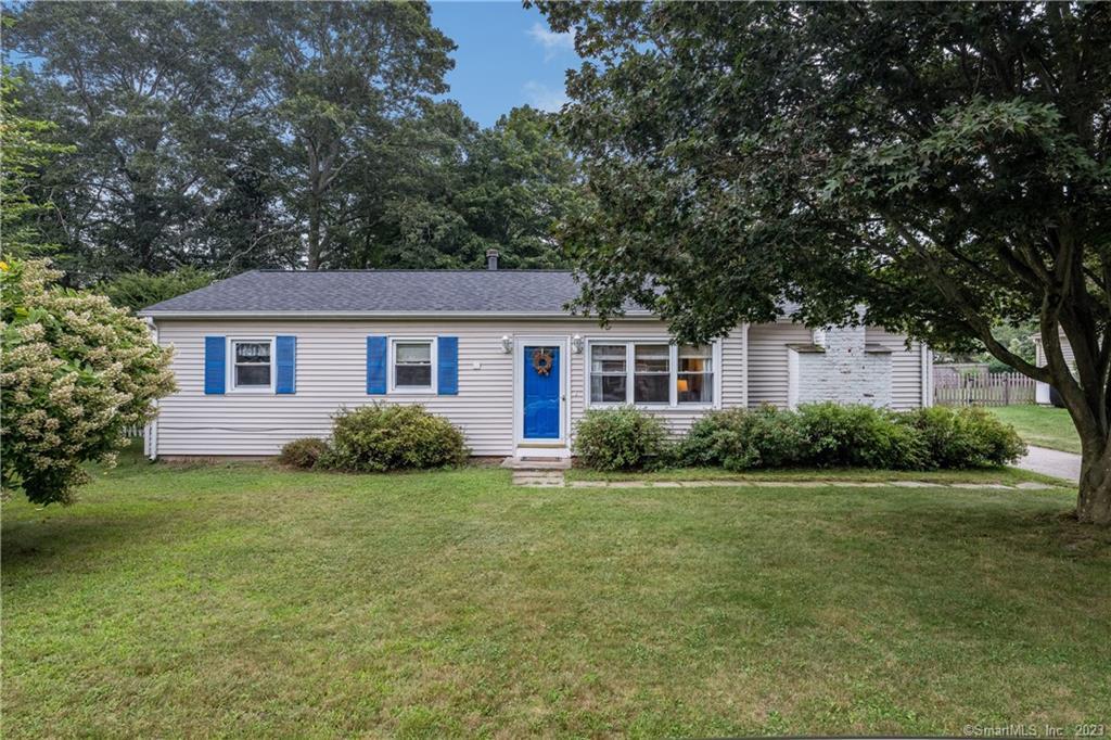 a view of a house next to a big yard and large trees