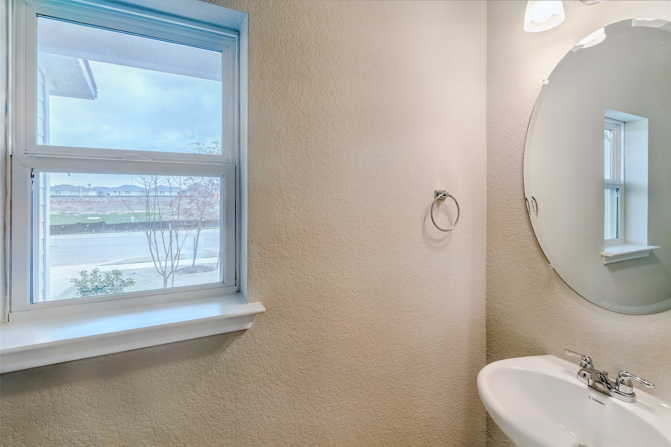113 Watercourse Way Bastrop, TX 78602 - Photo 14 of 32 a bathroom with a sink a mirror and next to a window
