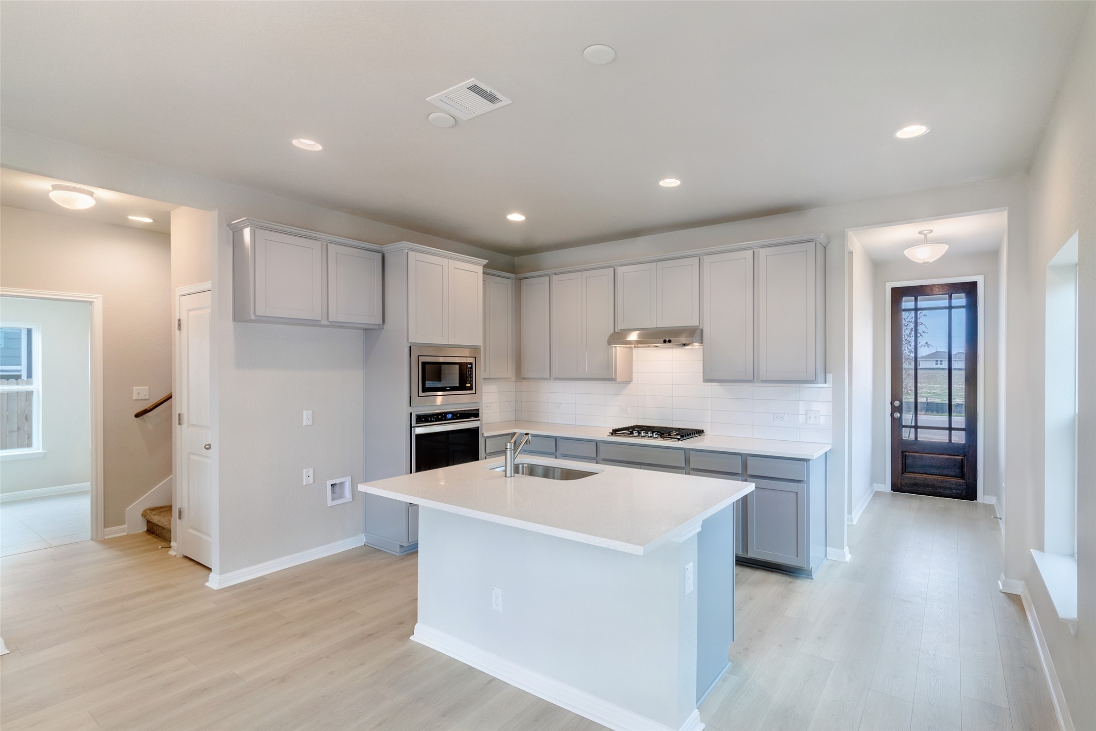 113 Watercourse Way Bastrop, TX 78602 - Photo 4 of 32 a kitchen with a sink a stove a refrigerator and a refrigerator
