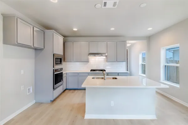 a kitchen with stainless steel appliances a refrigerator sink and stove