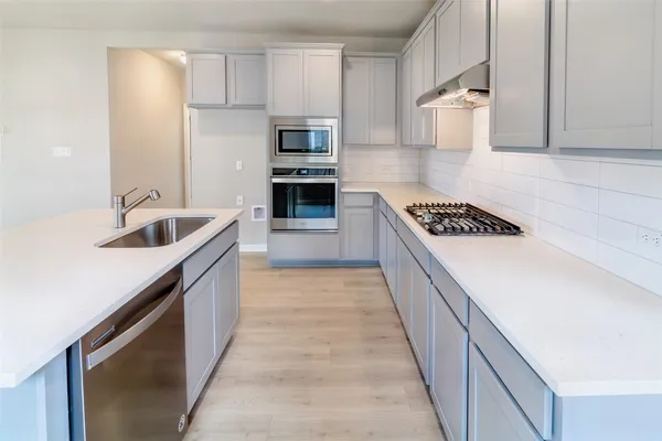 a kitchen with kitchen island a sink stove and cabinets