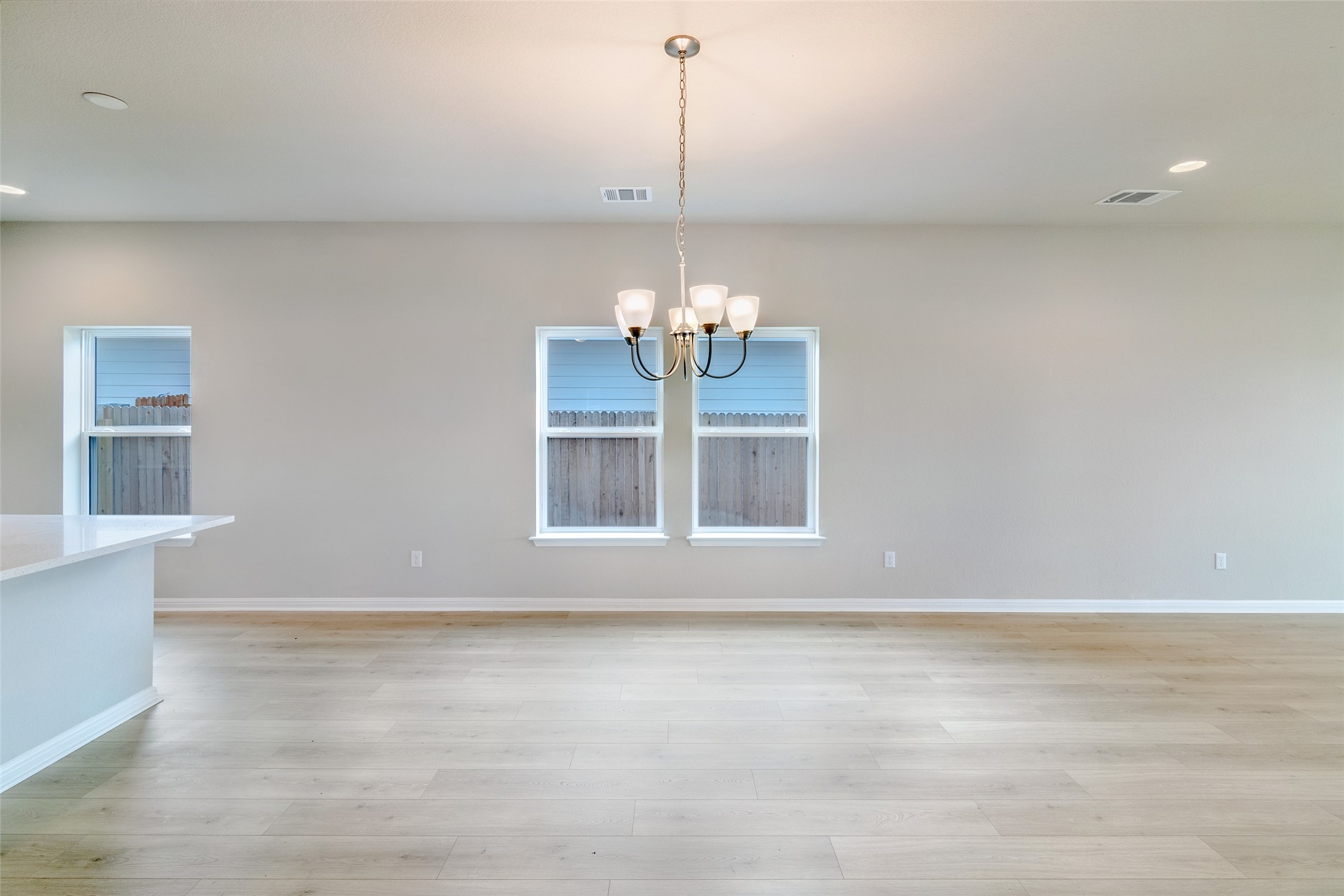 113 Watercourse Way Bastrop, TX 78602 - Photo 9 of 32 a view of a room with window wooden floor and a chandelier