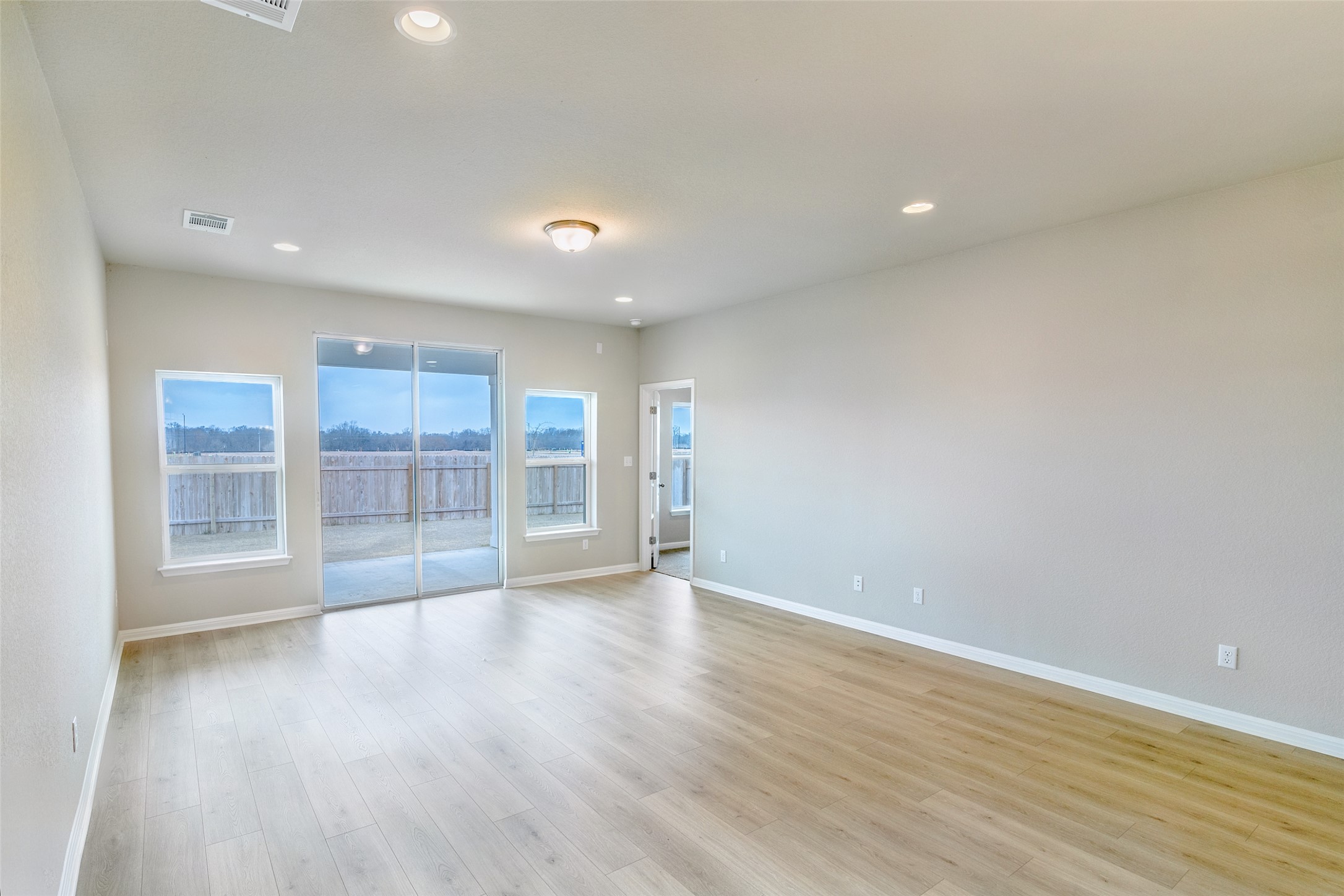 113 Watercourse Way Bastrop, TX 78602 - Photo 10 of 32 wooden floor in an empty room with a window