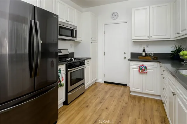 a kitchen with a refrigerator stove and wooden cabinets
