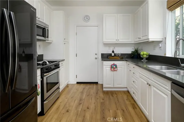 a kitchen with granite countertop a refrigerator and a sink