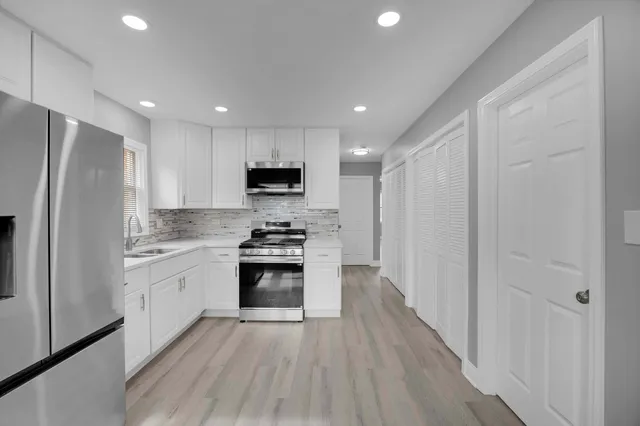 a kitchen with stainless steel appliances a refrigerator a stove top oven a sink and dishwasher