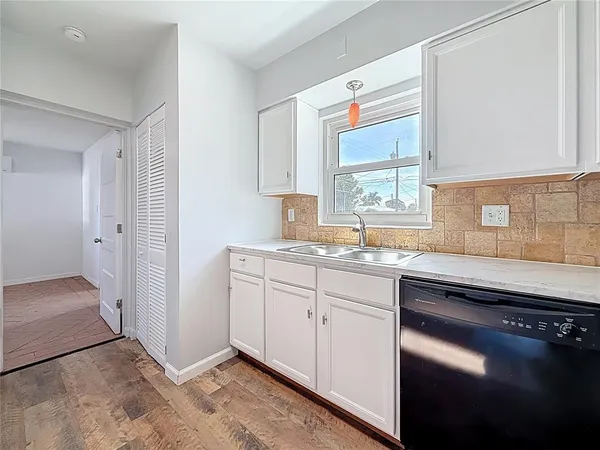 a kitchen with a sink cabinets and a window