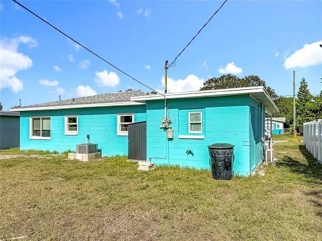 a view of a house with backyard and a tree