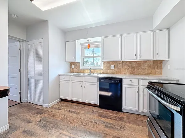 a kitchen with granite countertop a stove sink and cabinets