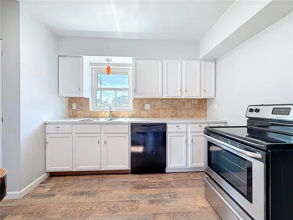 a kitchen with granite countertop white cabinets and appliances