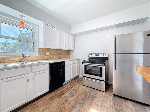a kitchen with granite countertop a refrigerator stove and sink