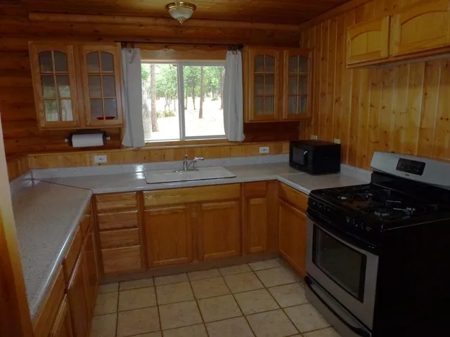 a kitchen with granite countertop a stove sink and cabinets