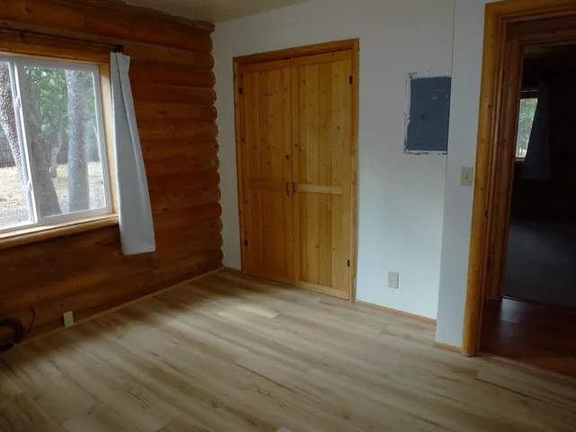 a view of a room with wooden floor and a window