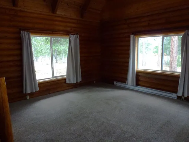 a view of room with hardwood flooring and a ceiling fan