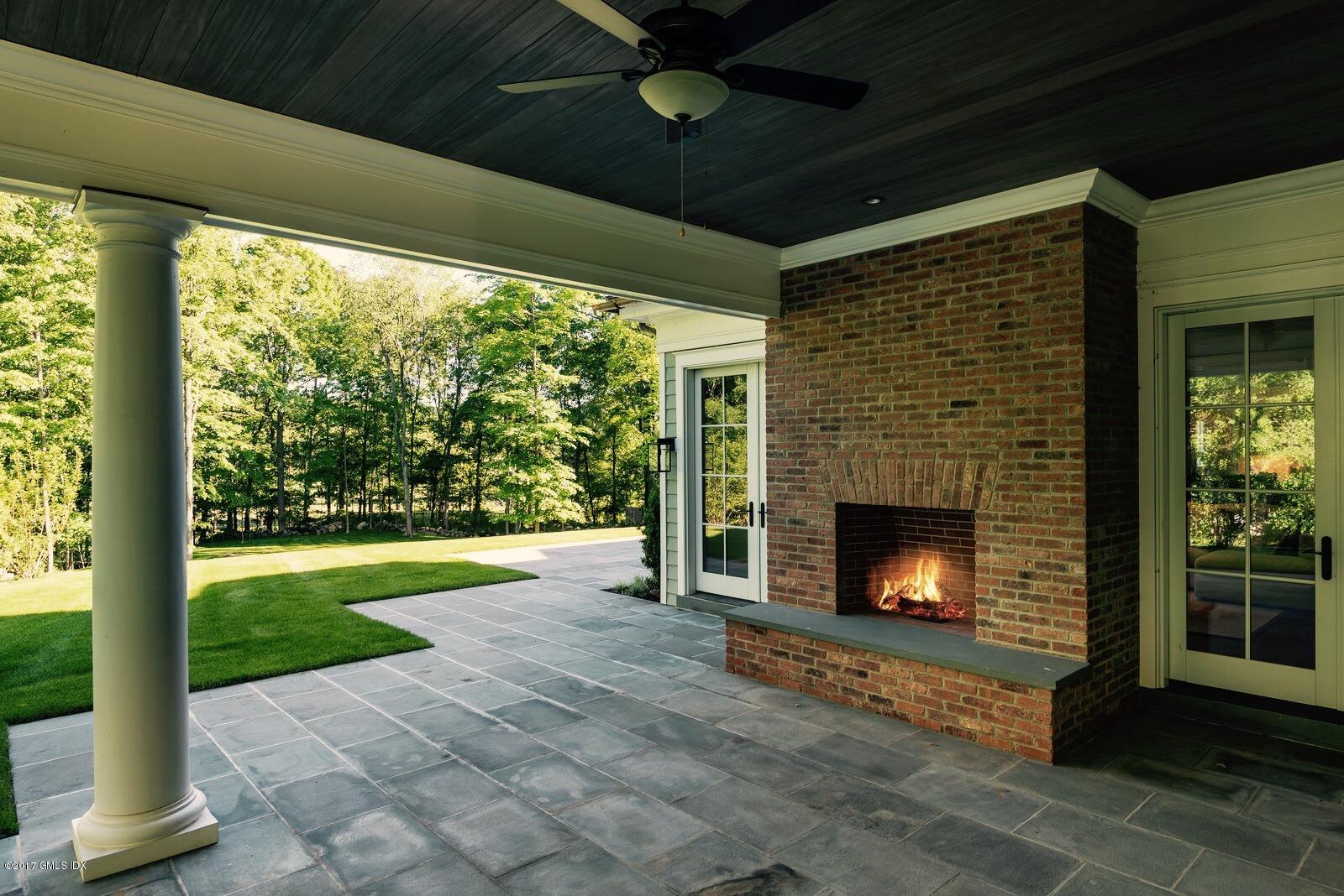 49 Byfield Lane Greenwich, CT 06830 - Photo 12 of 14 a living room with a fireplace and a floor to ceiling window