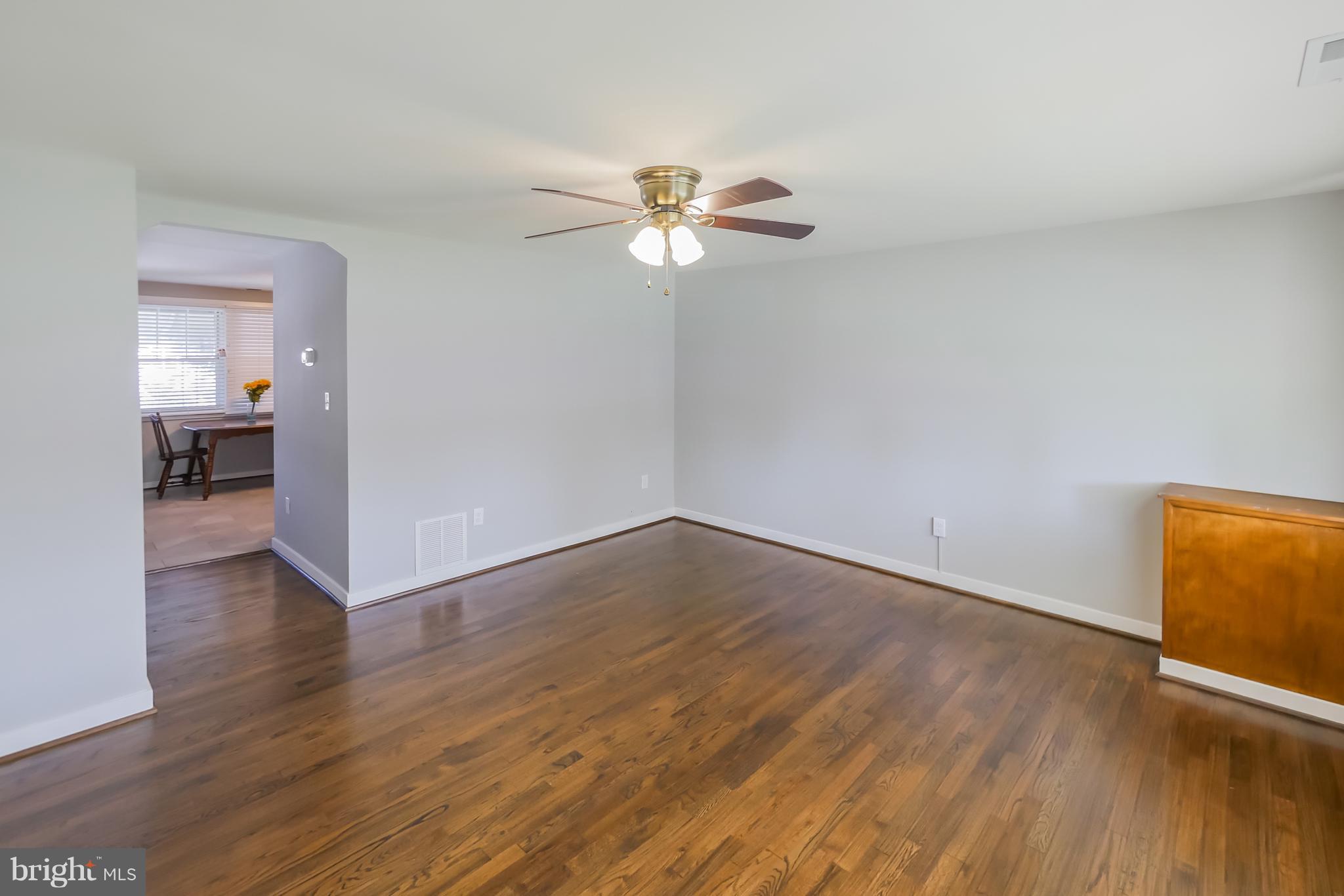 4410 Annapolis Road Baltimore, MD 21227 - Photo 2 of 31 a view of a room with wooden floor and a ceiling fan