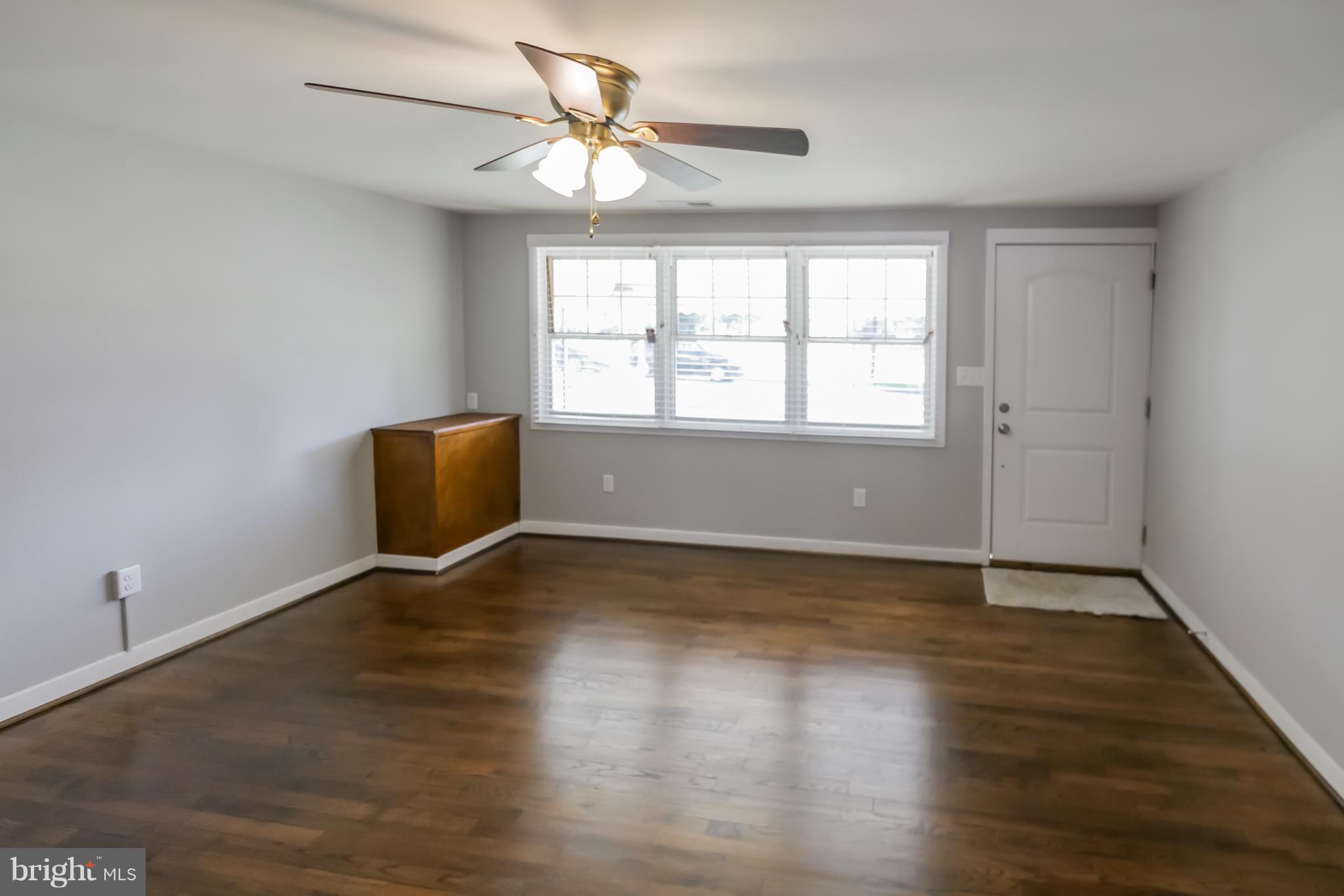 4410 Annapolis Road Baltimore, MD 21227 - Photo 3 of 31 an empty room with wooden floor and windows
