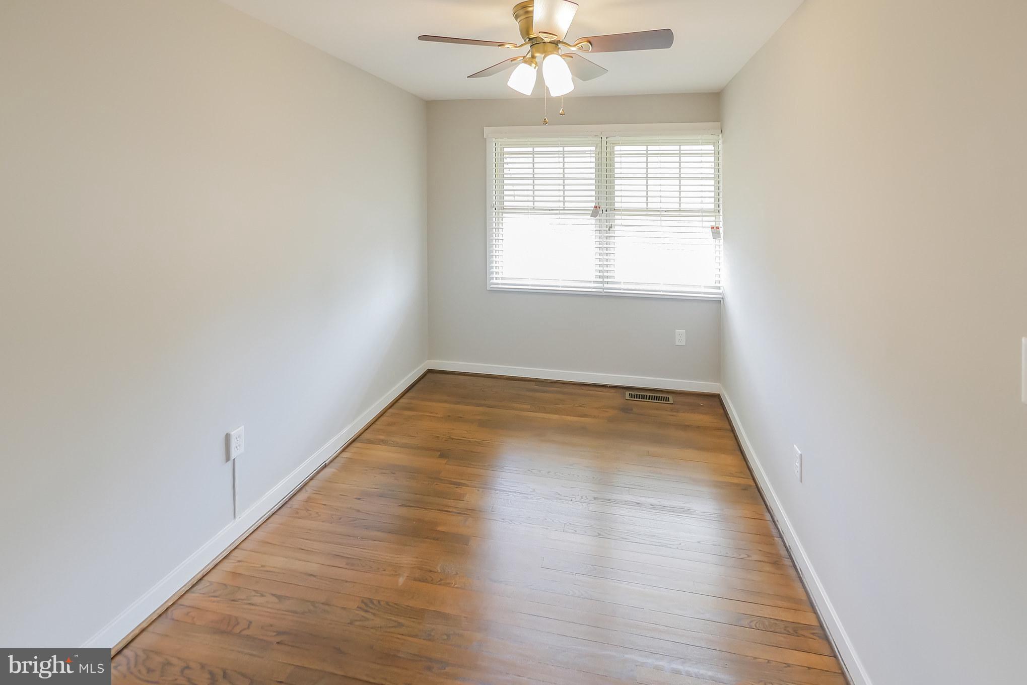 4410 Annapolis Road Baltimore, MD 21227 - Photo 22 of 31 an empty room with wooden floor fan and windows