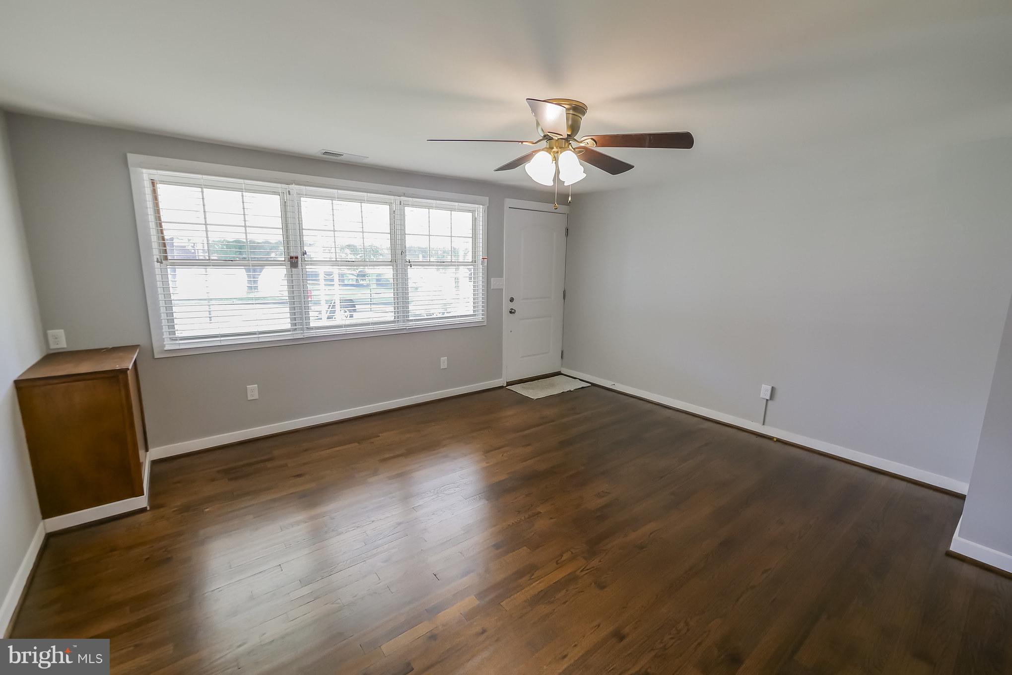 4410 Annapolis Road Baltimore, MD 21227 - Photo 4 of 31 an empty room with wooden floor fan and windows