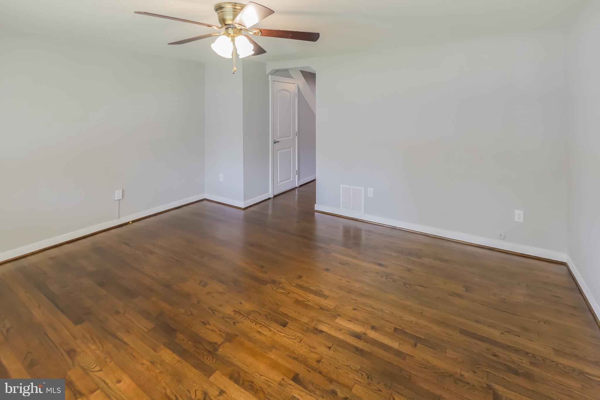 4410 Annapolis Road Baltimore, MD 21227 - Photo 5 of 31 an empty room with wooden floor fan and windows
