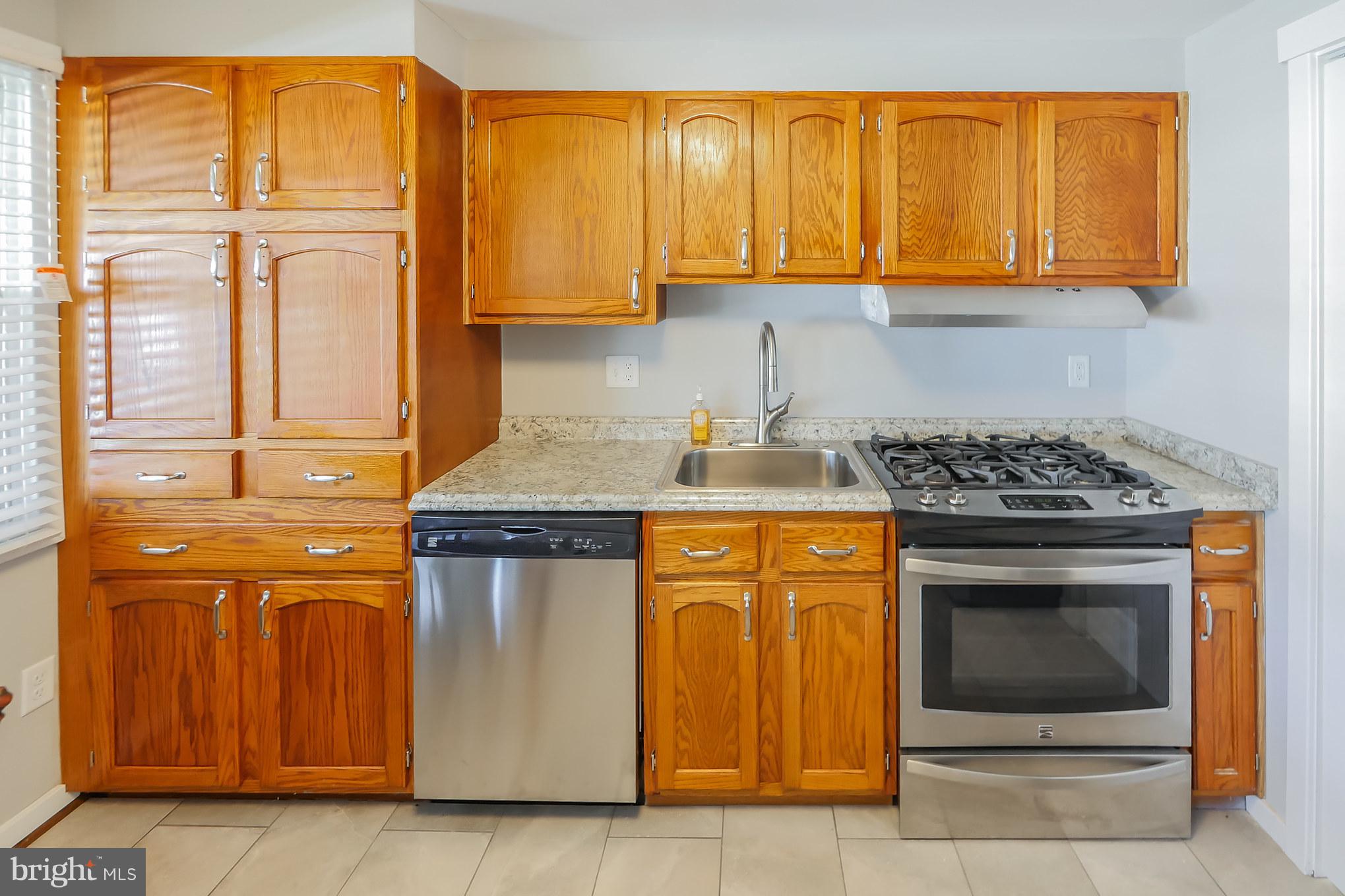 4410 Annapolis Road Baltimore, MD 21227 - Photo 9 of 31 a kitchen with stainless steel appliances granite countertop a stove and cabinets